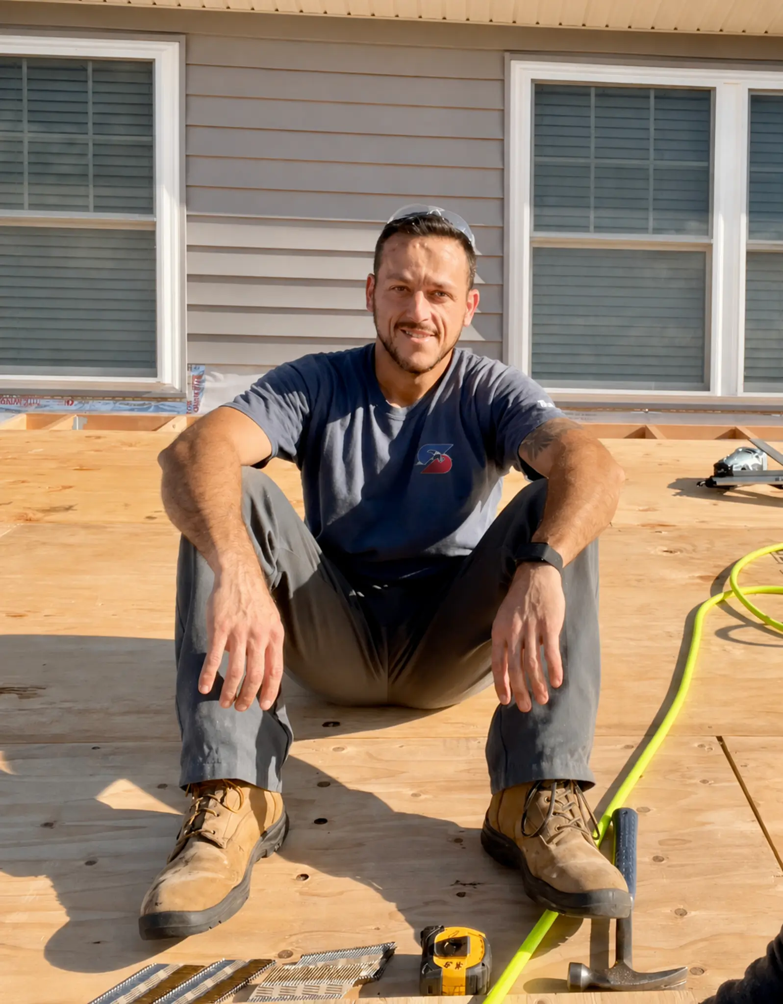 Chris Stergion seated on a roof during construction