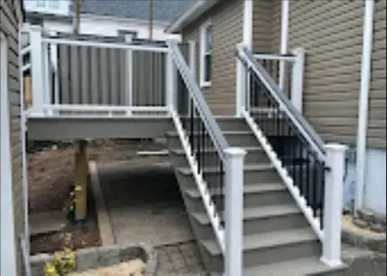 Completed gray deck stairs with white posts and railings