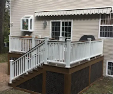 Raised deck with white railing and enclosed lower area