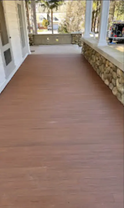 Finished decking across a covered porch with stone accents