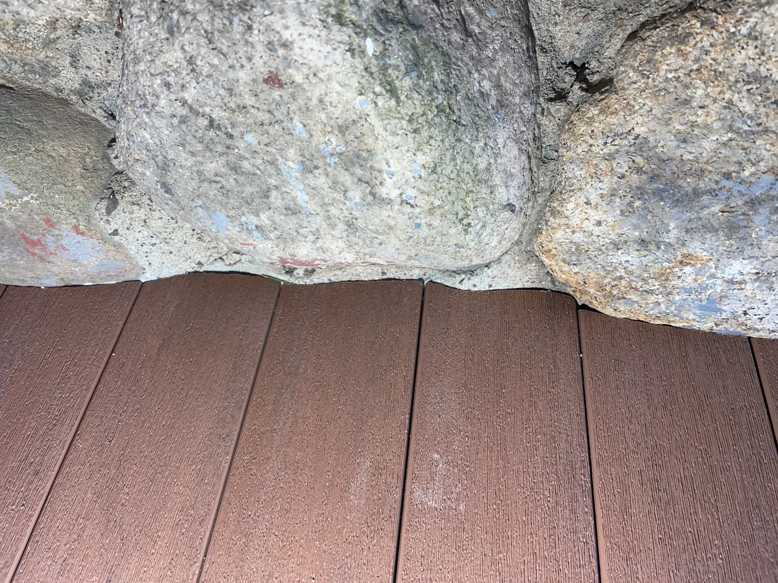 Close view of decking carefully fitted around natural stone