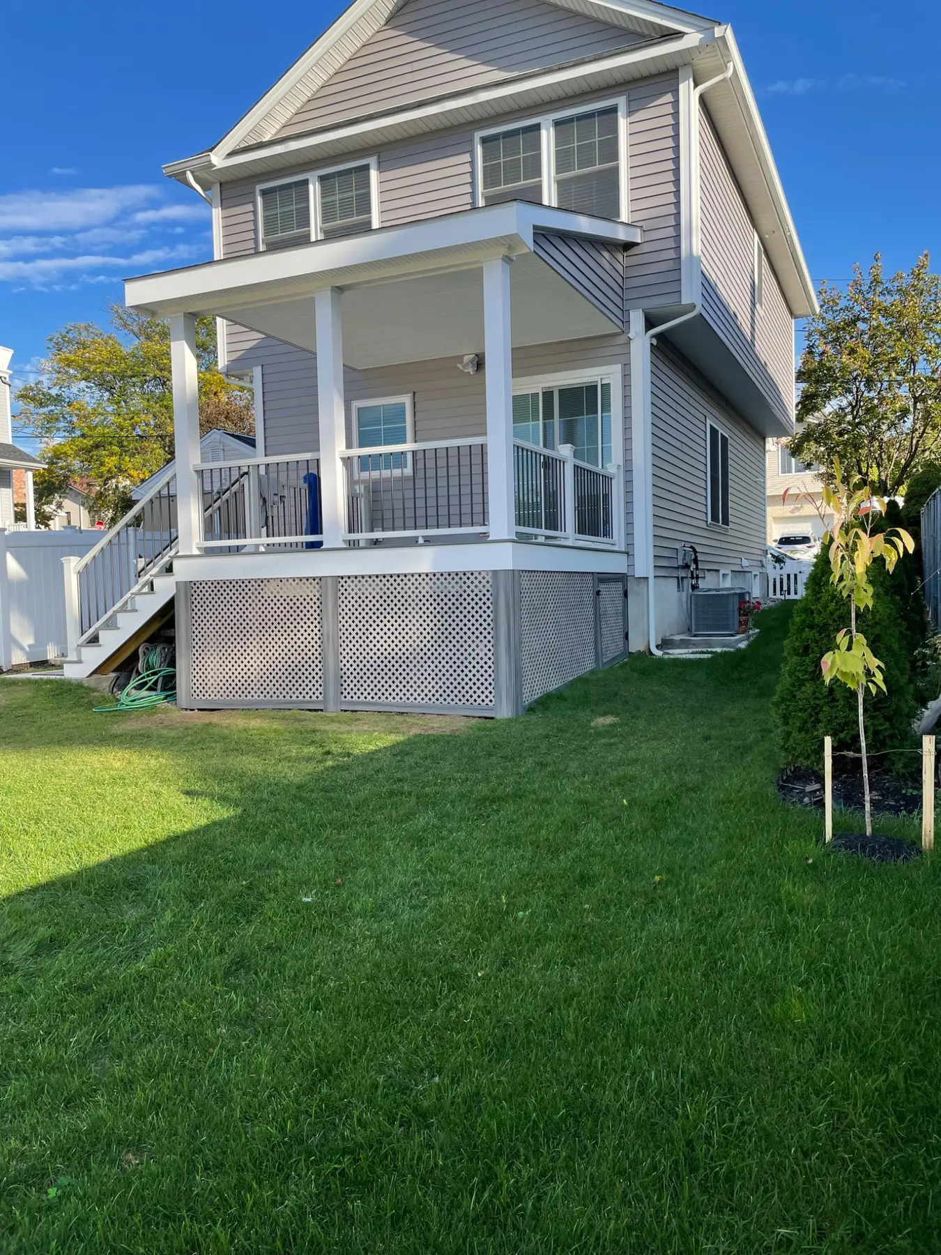 Wide exterior view of the covered composite deck, roof, railing and stairs